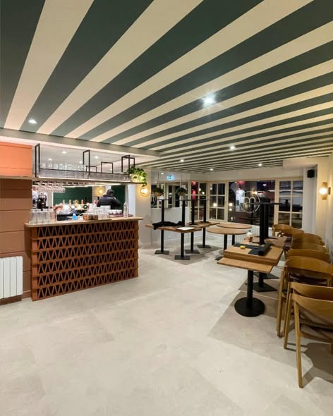 Café restaurant réaménagé, bar en briques ajourées et plafond rayé vert et blanc