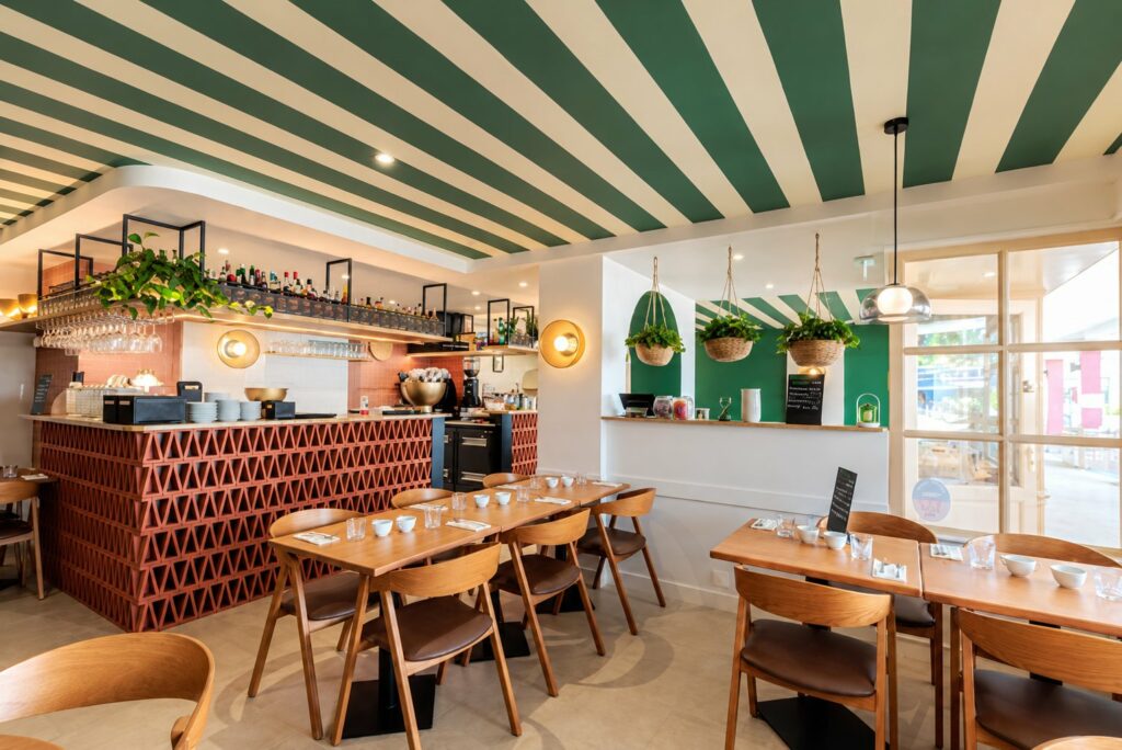 Salle d’une crêperie réaménagée à Arzon : bar en claustra de terre cuite et plafond rayé