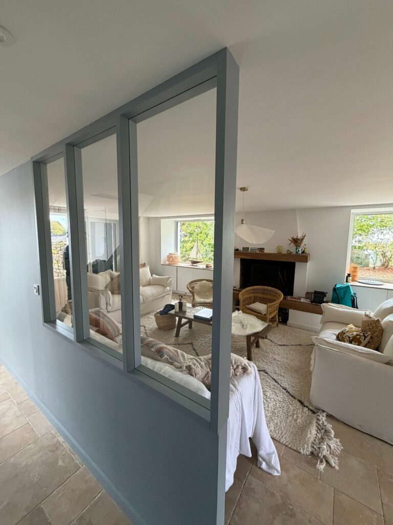 Cloison vitrée en bois peint entre l’entrée et le séjour, maison rénovée dans le Morbihan